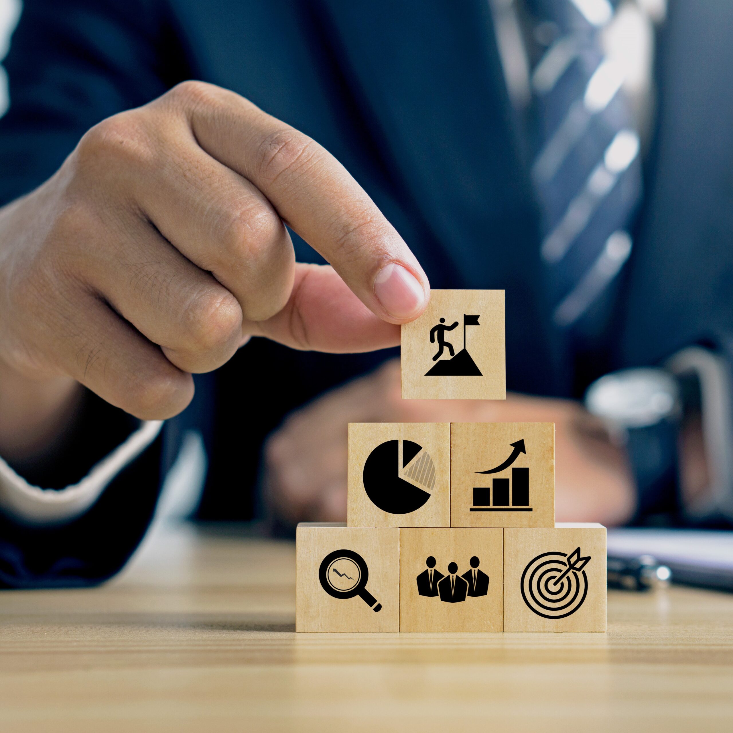 KPI, Key Performance Indicator.Businessman holds wooded cube with KPI icon to presentation, question feedback and planning ideas.